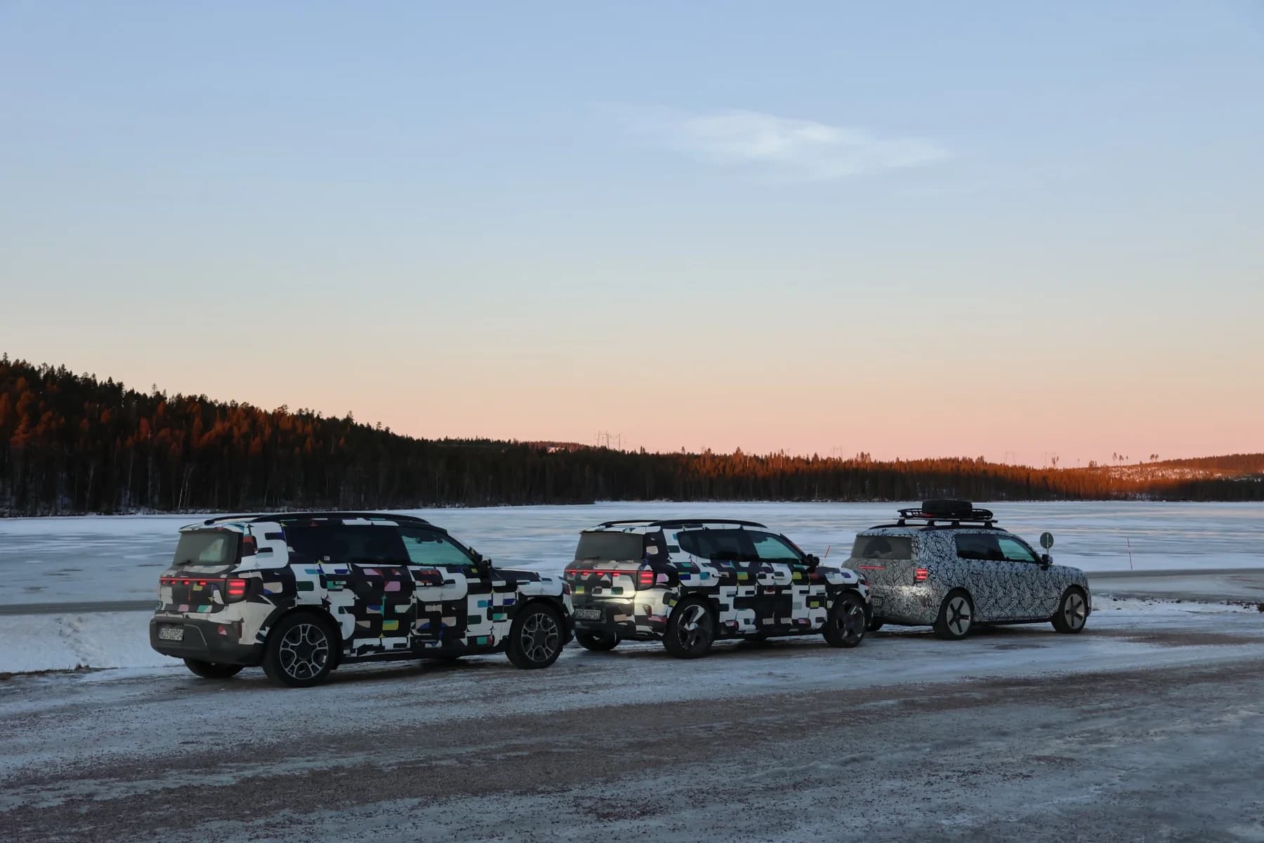 smart #5 camouflaged electric SUV prototypes during Scandinavian winter validation near a forest